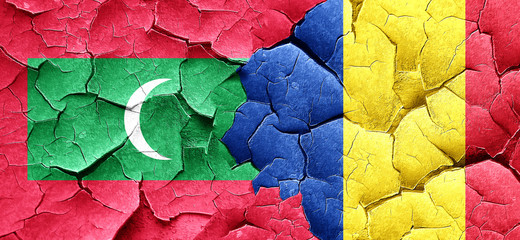 Maldives flag with Romania flag on a grunge cracked wall