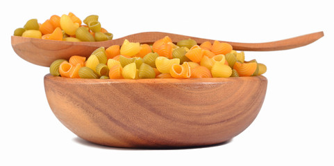 Colored uncooked italian pasta pipe rigate in a wooden bowl on a