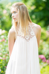 Naklejka premium Portrait of beautiful natural young woman in the rose garden