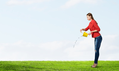 Girl pouring water from bucket