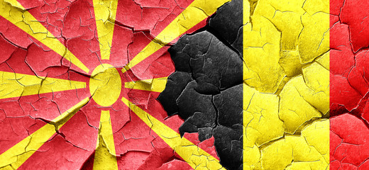 Macedonia flag with Belgium flag on a grunge cracked wall