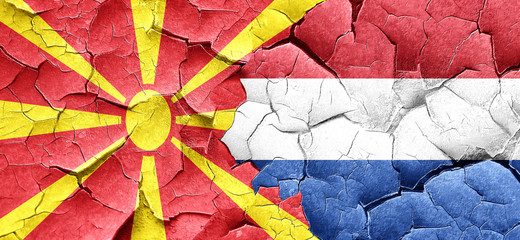 Macedonia flag with Netherlands flag on a grunge cracked wall