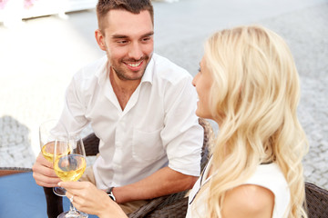 happy couple drinking wine at open-air restaurant