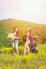 Beautiful young boho sisters outdoors on sunny summer day