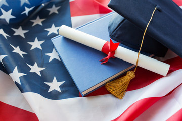 bachelor hat and diploma on american flag