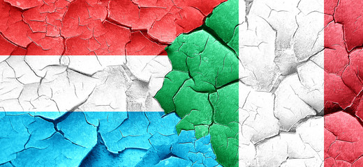 Luxembourg flag with Italy flag on a grunge cracked wall
