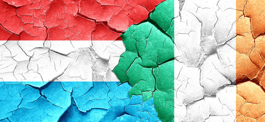 Luxembourg flag with Ireland flag on a grunge cracked wall