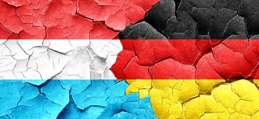 Luxembourg flag with Germany flag on a grunge cracked wall
