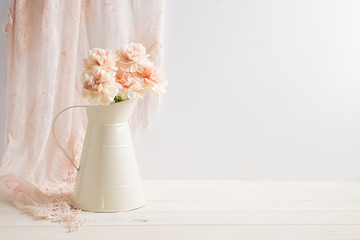 Mockup styled stock image of carnations in a cream jug with a piece of lace behind the jug. You can place your business promotion, blog title, quote, headline or image in the space beside the jug.