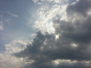 Blue sky with dark clouds  and sunlight