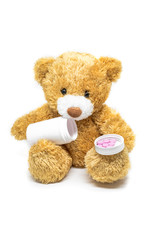 Toy teddy bear with medicine pill isolated on white background