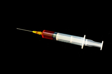 Syringe with blood on a black background