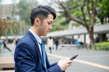 Young business man looking at cellphone