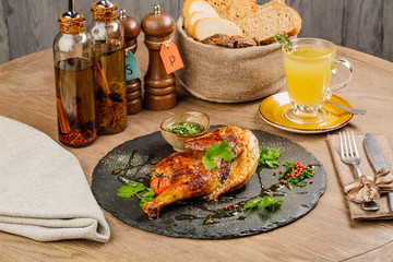 chicken Tabaka with sauce on stone plate.