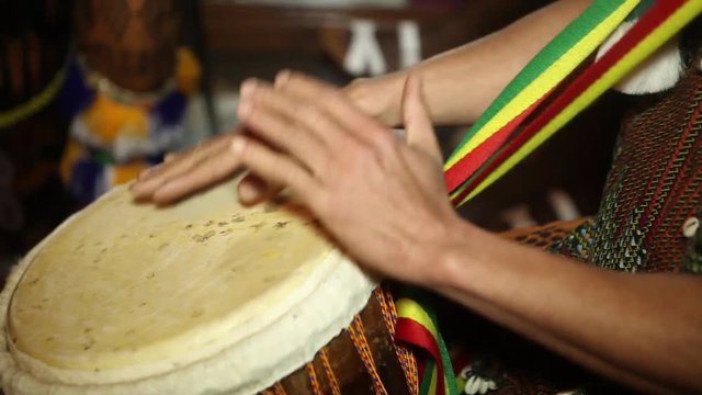 African Percussion - Traditional music. Closeup of man's hands drumming out a beat on an African skin-covered djembe hand drum.