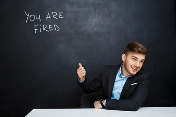 image of young man over blackboard with  text you are fired