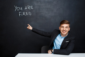 image of young man over blackboard with  text you are fired