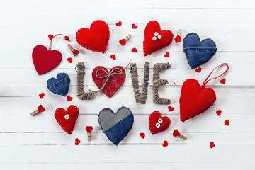 Frame from a variety of denim and red hearts on a white painted