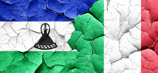 Lesotho flag with Italy flag on a grunge cracked wall