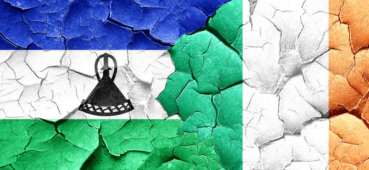 Lesotho flag with Ireland flag on a grunge cracked wall