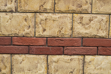 Masonry of bright blocks of stone with brick inlays