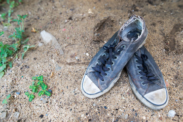 Old sneakers placed on the sand