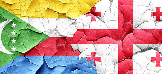 Comoros flag with Georgia flag on a grunge cracked wall