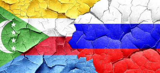 Comoros flag with Russia flag on a grunge cracked wall