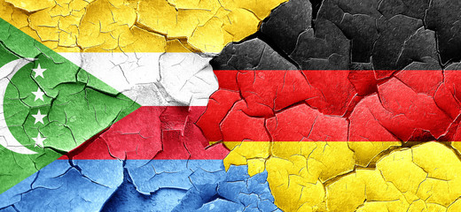 Comoros flag with Germany flag on a grunge cracked wall