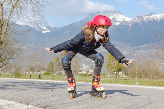 preteen girl on roller skates in helmet at track