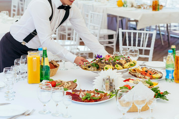 Waiter serving meal at festival table