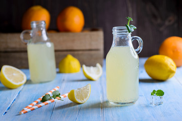 Ice cold citrus lemonade on wooden table on natural background