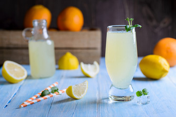 Ice cold citrus lemonade on wooden table on natural background