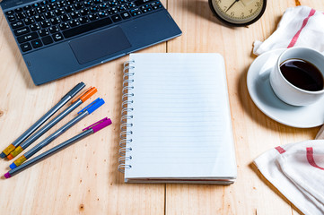 office working desk top view with laptop, notepad, glasses, and coffee cup