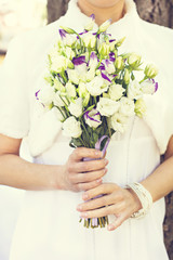 Obraz na płótnie Canvas the bride's bouquet. white and purple flowers.The bride holds the wedding bouquet.