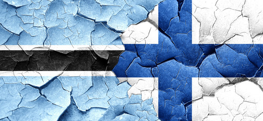 Botswana flag with Finland flag on a grunge cracked wall