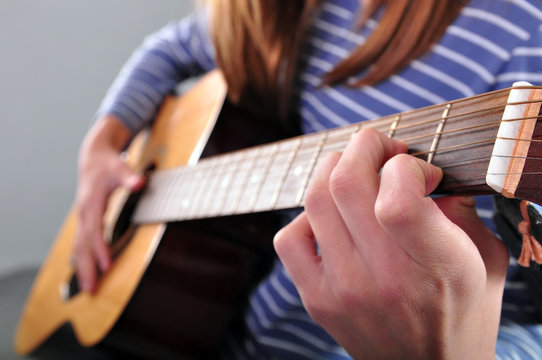teenager girl playing guitar