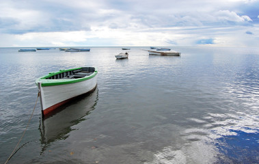 Reflection of boat at low tide on fisher village beach in Mauritius