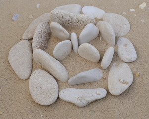Stones pebbles of different color and size of the sand in the form of symbols and figures
