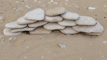 Stones pebbles of different color and size of the sand in the form of symbols and figures
