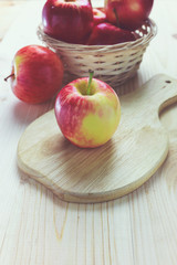 Fresh red apples. There are apple on the support and in the wood bowl.