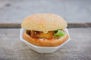 Classic American burger fast food. Big double burger at wood. Hamburger with fresh vegetables and meat. Burger with cheese, beef, tomato, lettuce. Cheeseburger at rustic wooden background.