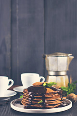 .chocolate pancakes with chocolate sauce. coffee. breakfast