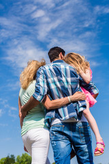 Familie, sich umarmend, Rücken zur Kamera leichte Untersicht