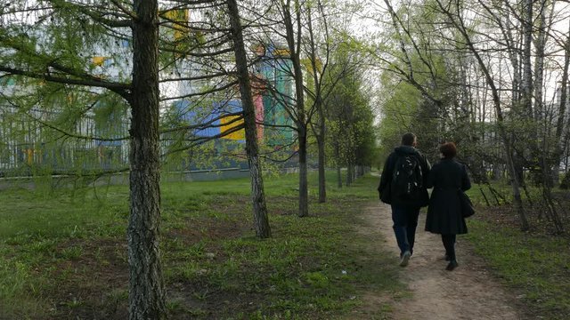 Senior Couple Walking on a Path Surrounded Green Trees