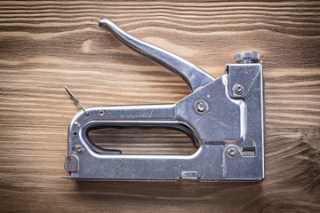 Metal staple gun on wooden board construction concept