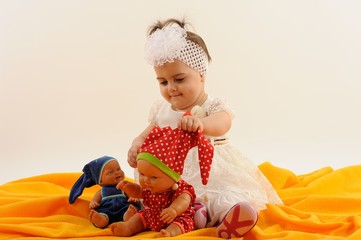 Cute and happy baby with doll smiling, laughing