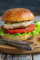 Burger with chicken, hot sauce and salad.