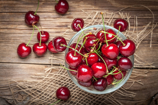 Cherries in a bowl on a wooden table.