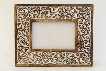 Wooden frame with carvings of leaves, painted white.